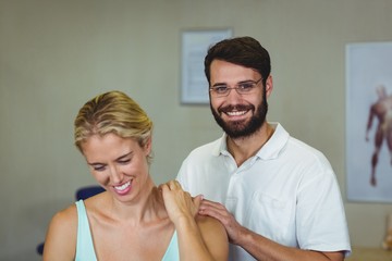 Male physiotherapist giving neck massage to female patient