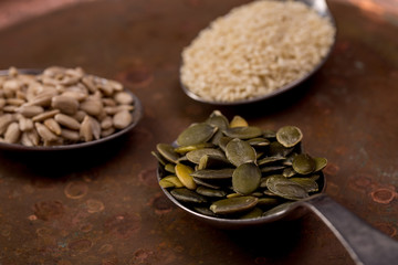Sesame, pumpkin and sunflower seeds on wooden background