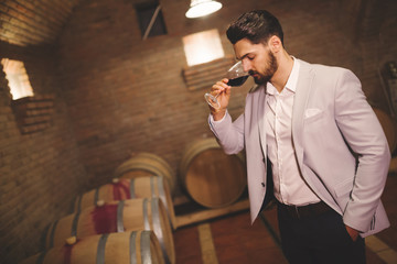 Winemaker inspecting wine in basement