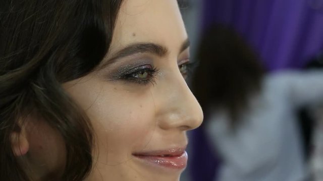 Make-up artist doing make up for young beautiful bride applying wedding make-up