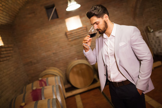Winemaker inspecting wine in basement