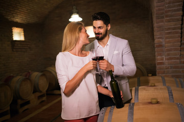 People tasting wine in winery basement
