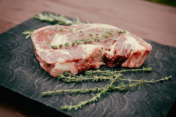 Rib eye steak on wooden board, toned