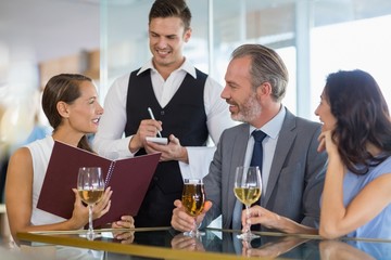 Waiter taking the order from a businessman and his colleagues
