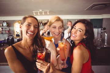 Happy female friends holding glass of cocktail