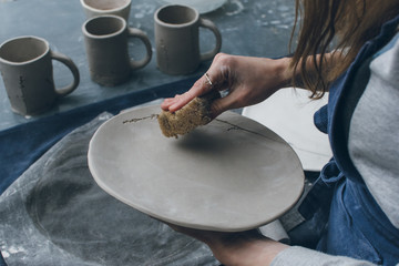 Unrecognizable female potter smoothing dish