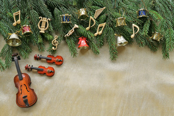 Musical notes, instruments on christmas tree brunch on golden background 