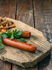 Grilled sausages with toasted bread on wood background. Close-up