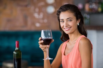 Smiling woman holding glass of red wine