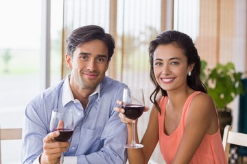 Portrait of couple holding glass of red wine
