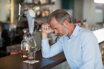 Tired man leaning his elbow on the counter