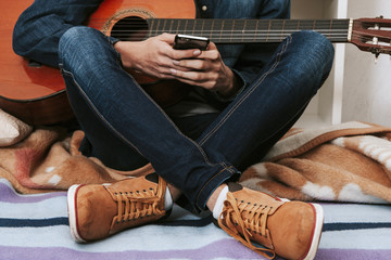 hands with the mobile phone and the guitar