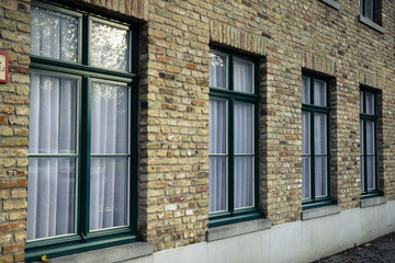 Brick wall with four windows in Bruges, Belgium