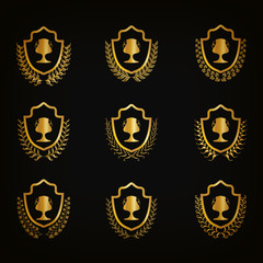 Obraz premium Set of luxury golden shields with laurel wreaths, champion cups. Filigree elements, award, emblem, icon, symbol, logo for web, page design Vector illustration EPS10