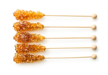 Brown amber sugar crystal on wooden stick.