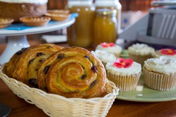 Close-up of cupcakes and spiral pastries on display counter