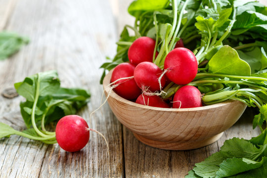 Red radishes in a wooden bowl.