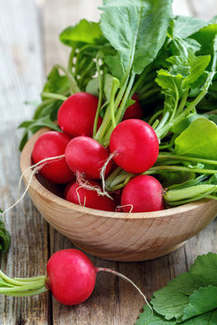 Wooden bowl with a red radish.
