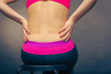 Woman with medical kinesio taping on back