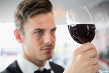 Waiter looking at a glass of wine