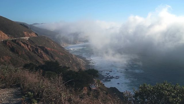 Thick fog from the Pacific coast moving into the PCH in Big Sur California looks like a tidal wave