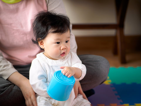 Asian baby girl playing stacking cups