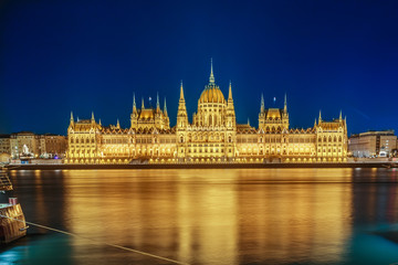 Fototapeta premium Budapest Parliament building at night on the Danube river in Hungary.