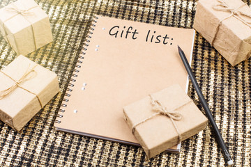 Christmas or New Year presents and notepad on golden background