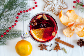 Christmas mulled wine with spices in cup on wooden background