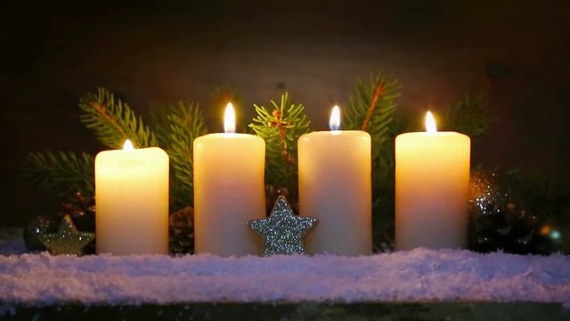 Four burning advent candles and Christmas decoration.