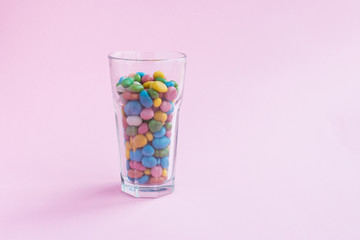 Glass candy on pink background. Sugar cocktail