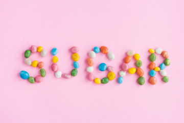 Word sugar candy written on pink background