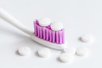 concept toothache with toothbrush and pills at white background