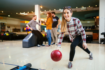 Beautiful woman bowling with friends