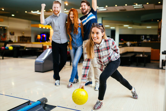 Friends having great time playing bowling