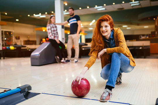 Beautiful woman bowling with friends