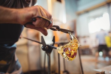 Glassblower shaping a molten glass