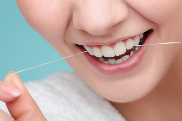 Woman smiling with dental floss.