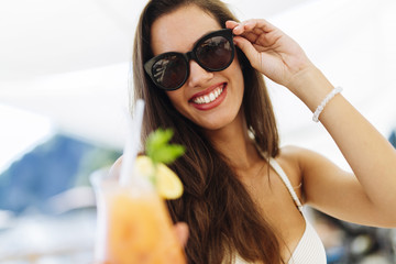 Attractive happy woman drinking cocktail