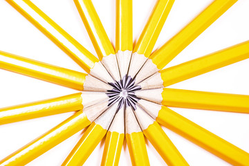 Drawing pencils arranged in a circle creating an abstract sunshine - Powered by Adobe