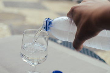 Closeup on pouring water from bottle into glass