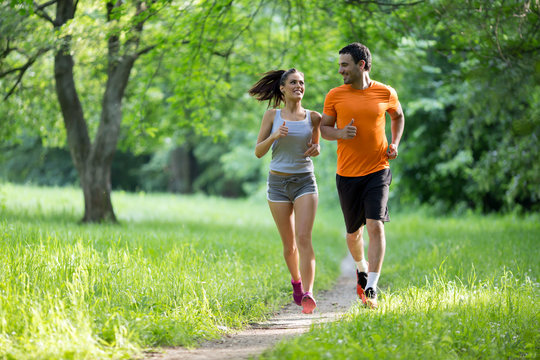 Healthy fit couple running in nature