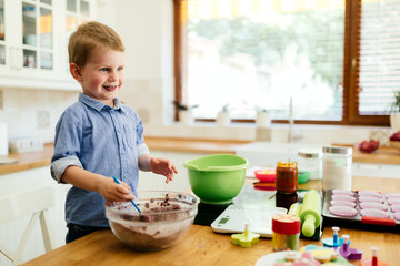Child helping mother make muffins
