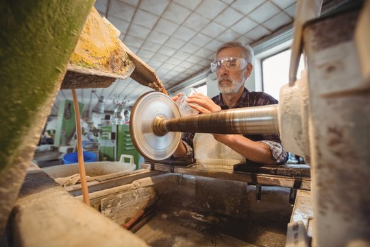 Glassblower polishing and grinding a glassware