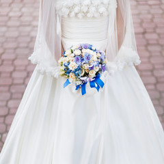 Fototapeta na wymiar bride holding bouquet of various flowers