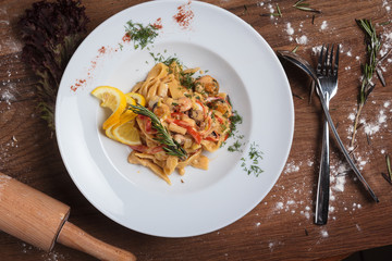 Concept: restaurant menus, healthy eating, homemade, gourmands, gluttony. Pasta with seafood on weathered wooden background. Top-down view.