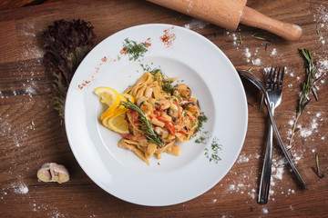 Concept: restaurant menus, healthy eating, homemade, gourmands, gluttony. Pasta with seafood on weathered wooden background. Top-down view.