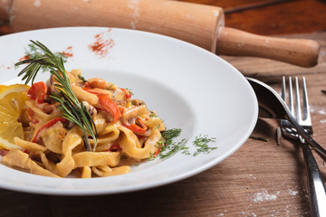 Concept: restaurant menus, healthy eating, homemade, gourmands, gluttony. Pasta with seafood on weathered wooden background.