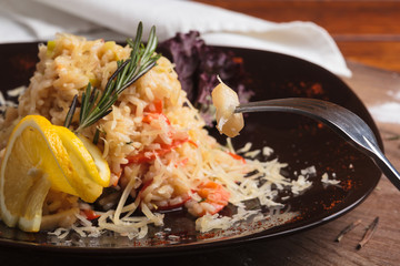 Concept: restaurant menus, healthy eating, homemade, gourmands, gluttony. Risotto with seafood on a weathered wooden background.