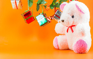 Christmas gift boxes with teddy bear on Orange background, New y